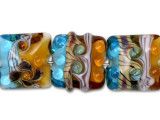 These gorgeous beads will make your designs the focus of attention. They are ideal for earrings, bracelets, and necklaces. Use just one bead on a cell phone finding. Mix them with pearls, gemstone beads, and PRESTIGE Crystal. The intense color of these seven beads simply has to be seen in person. These Grace Lampwork beads feature sunset orange color that fades into ocean blues. Swirls and dots cover the square surface of each bead, creating a textured display.This item is handmade, so appearances may vary. Length 12.5-14mm, Width 14.5-15.5mm
