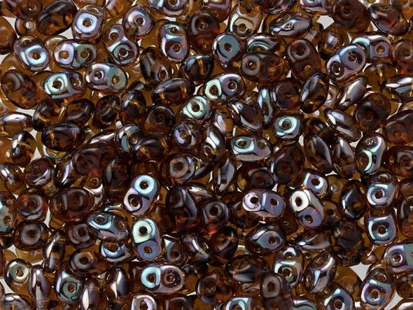 Smoky amber color combines with a metallic celestial gleam in these Matubo SuperDuo beads. Create intricate jewelry designs with Czech glass seed beads! Featuring a unique shape and two stringing holes, these seed beads add a special touch of creativity to your designs. They have tapered edges and nest up nicely when strung, making them ideal for floral and woven designs. Add a special touch to your jewelry with Czech glass seed beads!  