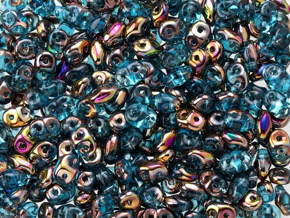 Teal blue color combines with metallic iridescent copper, gold, and purple tones in these Matubo SuperDuo beads. Create intricate jewelry designs with Czech glass seed beads! Featuring a unique shape and two stringing holes, these seed beads add a special touch of creativity to your designs. They have tapered edges and nest up nicely when strung, making them ideal for floral and woven designs. Add a special touch to your jewelry with Czech glass seed beads!  