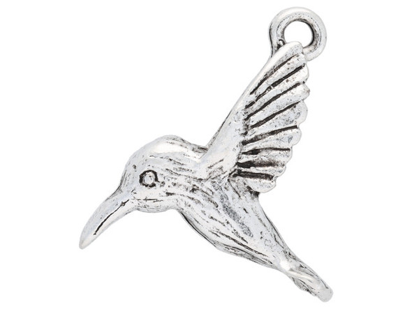 Brighten up designs with the Nunn Design antique silver-plated pewter hummingbird charm. This charm is shaped like a hummingbird in flight. The three-dimensional charm is full of detail, so it's a fun addition to any design. A loop is attached to the tips of the wings, so you can easily add it to bracelets, necklaces and earrings. It's the perfect decoration for charm bracelets. This charm features a versatile silver shine that will work anywhere. Hole Size 1.3mm/16 gauge, Length 19mm, Width 17mm