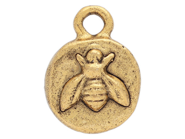 Bring some buzz to your designs with this itsy organic bee charm from Nunn Design. This small charm has a circular shape and features a raised design of a bee.  The back is plain. This charm has a golden color.