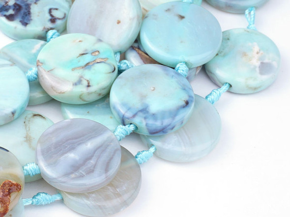 A beautiful blend of earthly color fills these terra agate beads from Dakota Stones. These beads feature a mix of greenish-blue and brown, creating Earth-like patterns with the brown spaces like continents in the vast ocean. Terra agate is a form of chalcedony made of quartz. These beads are treated and dyed agate. Because gemstones are natural materials, appearances may vary from piece to piece.