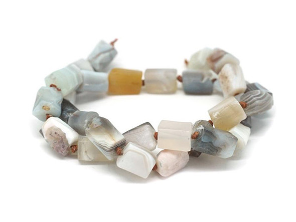 Decorate your jewelry designs with the gemstone style of these Dakota Stones beads. Botswana Agate displays highly defined parallel banding, usually in white on hues of brown, gray, pink, tan, apricot and purplish red. Botswana Agate was formed nearly 187 million years ago by lava flowing in waves from long faults in the earth. This lava rolled across the landscape, depositing layer upon layer of Quartz silicate to create the banding and patterns now prized in Botswana Agate. The beads on this strand can vary in size from about 7 x 10mm to about 8 x 13mm. Because gemstones are natural materials, appearances may vary from bead to bead.