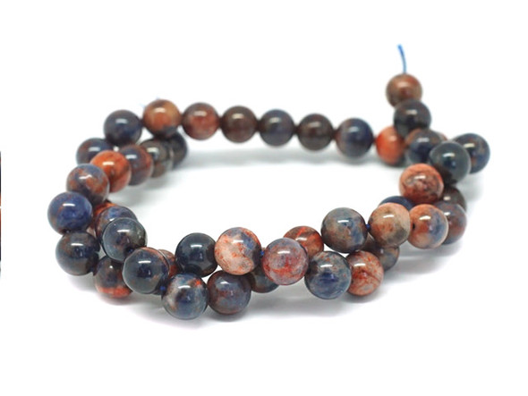 Add bold colors to your designs with this Dakota Stones dyed orange sodalite 8mm round bead strand. These beads feature a mix of bold blue and vibrant orange tones. They feature a classic round shape that is easy to add to your designs. Orange Sodalite has veins of orange, white and gray within the primarily bright to deep blue or black stone. Sodalite is named for its sodium content. Because gemstones are natural materials, appearances may vary from piece to piece.