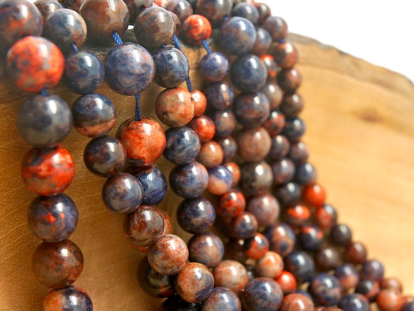 Add bold colors to your designs with this Dakota Stones dyed orange sodalite 8mm round bead strand. These beads feature a mix of bold blue and vibrant orange tones. They feature a classic round shape that is easy to add to your designs. Orange Sodalite has veins of orange, white and gray within the primarily bright to deep blue or black stone. Sodalite is named for its sodium content. Because gemstones are natural materials, appearances may vary from piece to piece.