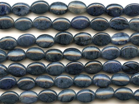 Treat yourself to daring style with the dumortierite 10x14mm oval beads from Dakota Stones. These beads feature a pleasing oval shape, perfect for showing off unique color in bracelets and necklaces. Each bead features a dark blue color streaked with veins of black or white. Dumortierite is a fibrous variably colored aluminum boro-silicate mineral. They crystals are vitreous and vary in color. Metaphysical Properties: Known as the "Stone of Order," dumortierite is said to help boost intellectual perception and to help in becoming more organized.Because gemstones are natural materials, appearances may vary from piece to piece. Each strand includes approximately 14 beads. 