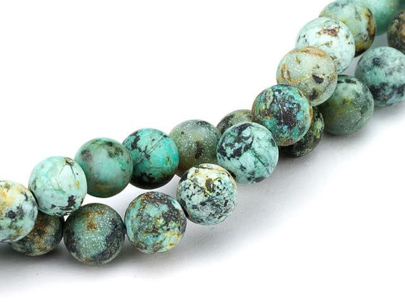 Add waves of color to designs with the Dakota Stones 6mm matte African Turquoise Jasper round beads. Available by the strand, these beads feature a perfectly round shape. They are the perfect size for necklaces, bracelets and earrings. Each bead features turquoise blue color with a black matrix and a matte surface. This stone is mined in Africa and is actually a type of spotted teal Jasper rather than turquoise. It is given its industry name because the matrix structure and shade is similar to that of turquoise. It has a Mohs hardness of 6. Metaphysical Properties: Often called the stone of evolution, African Turquoise Jasper encourages growth and development not only in the body, but in the mind. Some spiritualists believe that it will attract money to the wearer.Because gemstones are natural materials, appearances may vary from piece to piece. Each strand includes approximately 34 beads. 