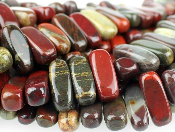 Add interest to your designs with the Dakota Stones 5x15mm Apple Jasper center-drilled flat chip beads. These beads feature a narrow oval chip shape. The stringing hole is drilled through the middle of the shape, so they are sure to stand out in designs. Layer them together for a modern look, or use a few as accents between smaller beads. These beads feature the rich and juicy colors of fresh apples hanging from a tree. Deep red mingles with hints of leafy green and bark brown. Pair them with earthy colors for a pleasing display. Jasper is an opaque variety of quartz, with a microscopic crystalline structure. Metaphysical Properties: Jasper is thought to improve vision and protect from unseen dangers at night.Because gemstones are natural materials, appearances may vary from piece to piece. Each strand includes approximately 34 beads. Length 5-6mm, Width 14-18mm