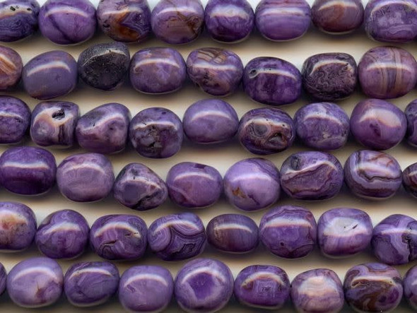 For natural shape and deep color, try the purple crazy lace agate 8x10mm tumble nugget beads from Dakota Stones. These beads feature a pebble shape and swirling purple color mixed with bands of burgundy and black. They have a Mohs hardness of 6.5-7. Mexican crazy lace agate is normally an opaque white gemstone with swirling patterns, but these beads are color enhanced to emphasize these beautiful patterns. Color enhancing is common amongst agates to make them fashionably relevant. Metaphysical Properties: Often called the happy stone, crazy lace agate promotes laughter and optimism. Because gemstones are natural materials, appearances may vary from bead to bead. Each strand includes approximately 14 beads.Diameter 8-10.5mm, Length 9-10.5mm