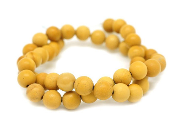 Bring sunny color to your designs with these yellow mookaite gemstone beads from Dakota Stones. These beads feature a matte yellow color and a classic round shape. Mookaite is a variety of Jasper that takes its name from Mooka Creek, near the Kennedy Ranges of Australia, the only region in the world where the stone is found.  Because gemstones are natural materials, appearances may vary from piece to piece.