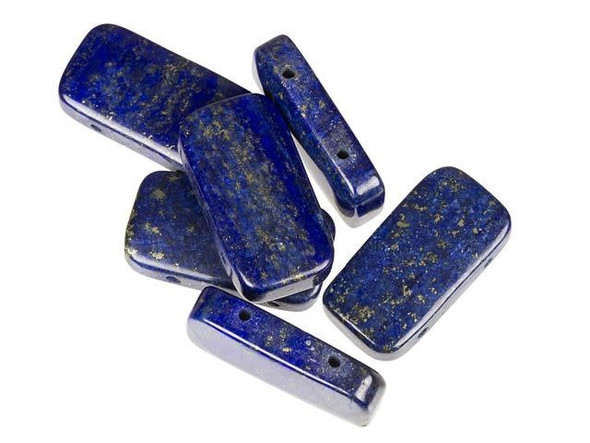 Create a luxurious gemstone display with these lapis beads from Dakota Stones. These beads are rectangular in shape and have smooth, rounded edges. The double-drilled holes make these beads perfect for use in watch bands. These gemstone beads feature the rich blue color lapis is known for. Lapis is a semi-precious stone that was among the first gemstones to be worn as jewelry. Metaphysical Properties: Lapis is said to enhance insight, intellect and awareness.Because gemstones are natural materials, appearances may vary from piece to piece. Each strand includes approximately 20 beads.