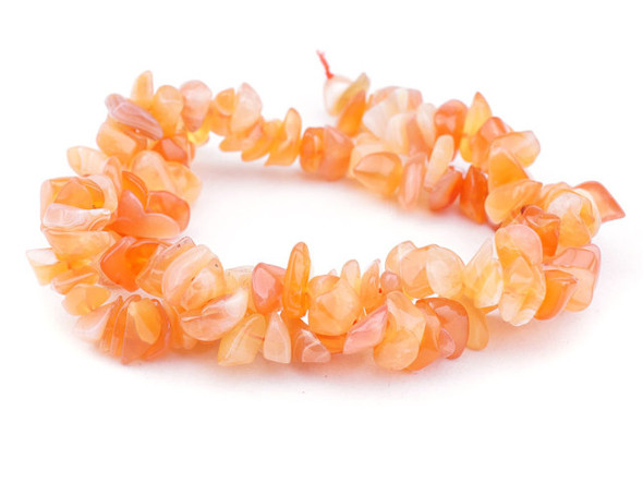 A warm glow fills these chalcedony beads from Dakota Stones. These beads feature a mix of bright orange colors. They have irregular chip shapes, perfect for organic styles. Layer them into necklaces, bracelets, and even earrings. Chalcedony is a naturally occurring, soft blue translucent stone. It is a member of the quartz family, a form of silica with a cryptocrystalline structure that incorporates moganite along with the quartz. Because gemstones are natural materials, appearances may vary from piece to piece.