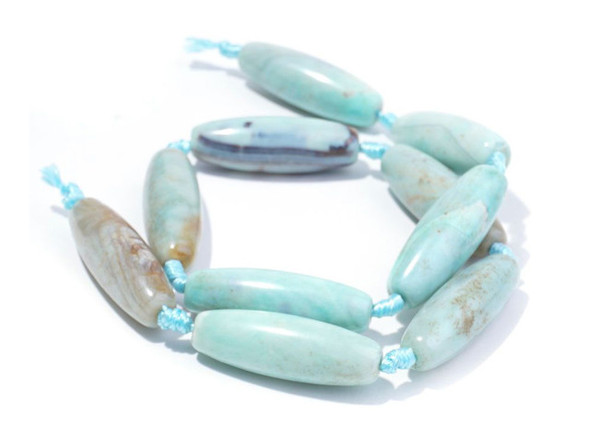 A beautiful blend of earthly color fills these terra agate beads from Dakota Stones. These beads feature a mix of greenish-blue and brown, creating Earth-like patterns with the brown spaces like continents in the vast ocean. Terra agate is a form of chalcedony made of quartz. These beads are treated and dyed agate. Because gemstones are natural materials, appearances may vary from piece to piece.