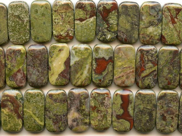 Add earthy drama to your designs with the dragon blood Jasper 10x20mm double drilled beads from Dakota Stones. Available by the strand, these beads feature a rectangular shape and two stringing holes drilled through the side. These beads feature mottled green flecks of color splashed with deep red tones. The two primary colors contrast and complement each other to form striking Jasper. Mined only in western Australia, the local legend surrounding this gemstone says that it is the remains of ancient dragons long dead, the green mottles representing the dragons' scales and the red matrix representing spatters of blood. These rectangular beads are great for using in watch bands. Dragon blood Jasper is part of the quartz family. Metaphysical Properties: Dragon blood Jasper enhances courage, strength and vitality.Because gemstones are natural materials, appearances may vary from piece to piece. Each strand includes approximately 20 beads.