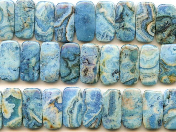 Imagine yourself in a desert oasis with these blue crazy lace agate 10x20mm double drilled rectangle beads from Dakota Stones. These fun rectangular beads feature swirling blue patterns mixed with occasional brown tones. You will feel the flair of the Southwest when you use these beads in your designs. The double-drilled holes make these beads perfect for using in watch bands. They have a Mohs hardness of 6.5-7. Mexican crazy lace agate is normally an opaque white gemstone with swirling patterns, but these beads are color enhanced to emphasize these beautiful patterns. Color enhancing is common amongst agates to make them fashionably relevant. Metaphysical Properties: Often called the happy stone, crazy lace agate promotes laughter and optimism. Because gemstones are natural materials, appearances may vary from bead to bead. Each strand includes approximately 20 beads. 