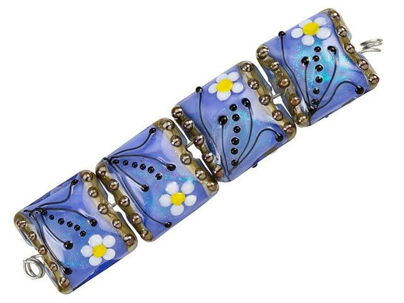 Sophisticated floral style fills these Grace Lampwork beads. These beads feature a square pillow shape with a subtle puffed dimension. The surface is decorated with a white and yellow daisy with black swirls and dots surrounding it. The inside of the glass shimmers with an elegant powder blue color that lights up with aqua glitter. Both sides of each bead are decorated, so they will look great from any angle. You can use these beads in matching jewelry sets for a fun display of style. This item is handmade, so appearances may vary. Dimensions: 15 x 15mm, Hole Size: 2.5mm