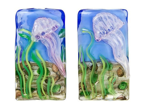 Looking for a unique bead to add to your handmade jewelry collection? Look no further than the Grace Lampwork Sea Jellies Kalera Focal Bead. With its bold rectangular shape and raised design of a striped pale purple jellyfish floating in front of green seaweed on the ocean floor, this bead will transport you under the sea. The design is displayed on both sides of the bead, so it will always look great from any angle. This handmade glass bead is truly one-of-a-kind, making it the perfect addition to your next DIY project. Let this bead be the centerpiece of your bracelet or slide it onto a head pin for an instant pendant that's sure to turn heads. Shop now and bring a touch of nature to your handmade creations!