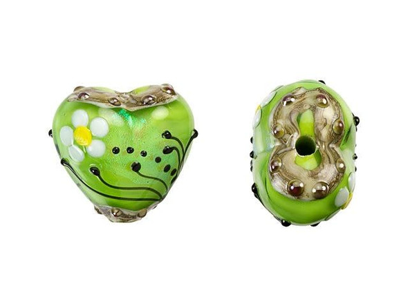 Looking to add a touch of natural beauty to your jewelry collection? Look no further than the Grace Lampwork Spring Green Florals Heart Focal Bead. Crafted from shimmering glass, this bead boasts a soft chartreuse green color that glimmers in the light. The heart-shaped bead is adorned with delicate white and yellow daisies and accented with black swirls and dots, giving it a whimsical, garden-inspired look. Whether you string it onto a head pin or add it to a beaded strand, this handmade bead is sure to add a special touch to all of your DIY creations.