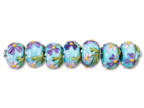 Add feminine whimsy to your designs using the Grace Lampwork Kiley's blue bouquet roundel bead strand. These rounded beads feature a puffed shape and are decorated with floral designs. Each flower displays purple petals with a yellow center. Against the pale blue background, these flowers look like they are swaying in the wind on a sunny day. Add these beads to bracelets or necklaces for a fun splash of color.This item is handmade, so appearances may vary. Diameter 13.5-14mm, Length 9-10mm
