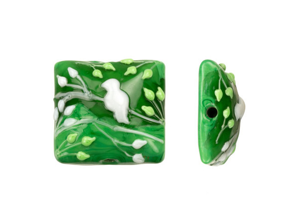 Go green with this Grace Lampwork bead. This bead features a square shape with a domed front. The front is decorated with a white bird on white branches along with light green branches and leaves. The inside of the glass shimmers with a forest green color. The back is flat and undecorated. String this bead onto a head pin for a quick pendant or try it at the center of bead embroidery. This item is handmade, so appearances may vary. Dimensions: 26 x 24mm, Hole Size: 2.5mm