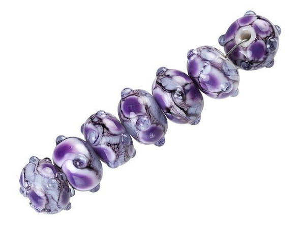 For fascinating style, try these Grace Lampwork beads. These glass beads feature mesmerizing patterns in lavender and periwinkle terms with hints of black and white swirls. Raised dots add texture. Use these outstanding beads in necklaces and bracelets for an unforgettable display. Use them with shining silver components for an eye-catching look.This item is handmade, so appearances may vary. Diameter 13.5-15.5mm, Length 9mm