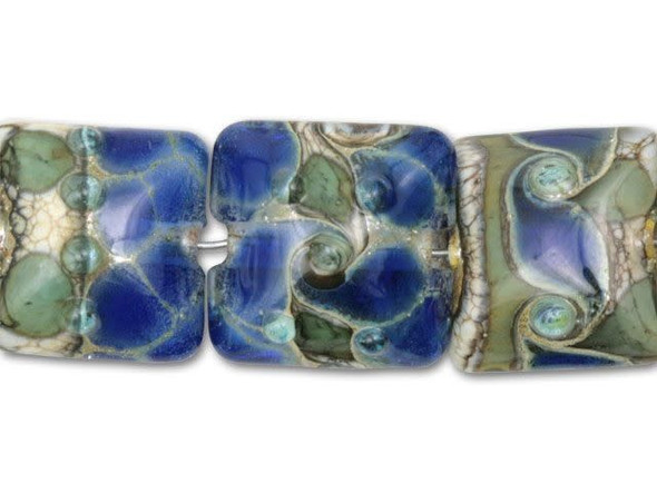 Try using this seven piece set of deep ocean blue lampwork pillow beads with silver to create a beautiful ocean-themed design. With their dark blue, beige, and green coloring, you'll hint at the ocean just by stringing them. The transparent blue glass in each square bead has a pattern over its surface that looks like drifting foam. Each bead features the same colors in a slightly different design. You can use them on a bracelet or necklace.This item is handmade, so appearances may vary. Length 15mm, Width 15.5mm