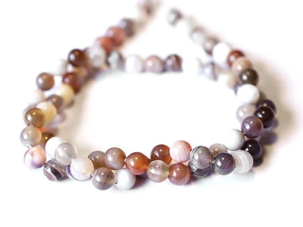 Decorate your jewelry designs with the gemstone style of these Dakota Stones beads. Botswana Agate displays highly defined parallel banding, usually in white on hues of brown, gray, pink, tan, apricot and purplish red. Botswana Agate was formed nearly 187 million years ago by lava flowing in waves from long faults in the earth. This lava rolled across the landscape, depositing layer upon layer of Quartz silicate to create the banding and patterns now prized in Botswana Agate.Because gemstones are natural materials, appearances may vary from piece to piece.