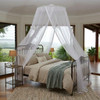 Round mosquito net hanging from its hoop over a king bed
