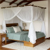 Cotton box mosquito net on a bamboo pole frame over a queen bed