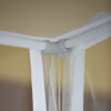 Box mosquito net hung from a curtain rod frame