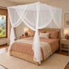 Sheer white box mosquito net hanging over a full size bed