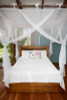 Box mosquito net draped over a single bed lifestyle view