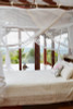 Mosquito net box suspended on bamboo poles tropical setting