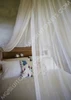 Classic round cotton mosquito net draped over a bed