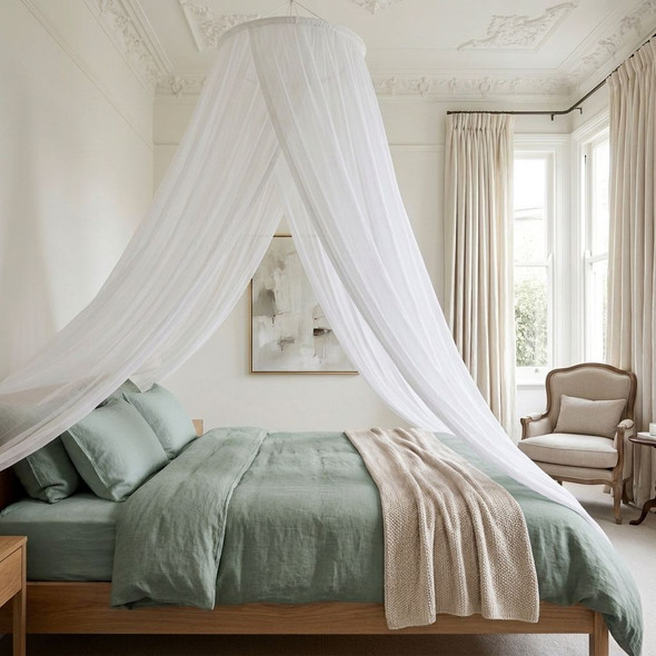 Round white silk bed canopy falling from a high ceiling over a queen or king bed