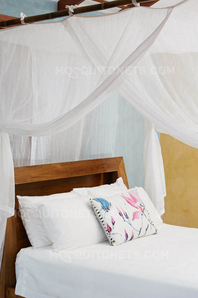 Cotton box mosquito net draped over a double bed lifestyle view