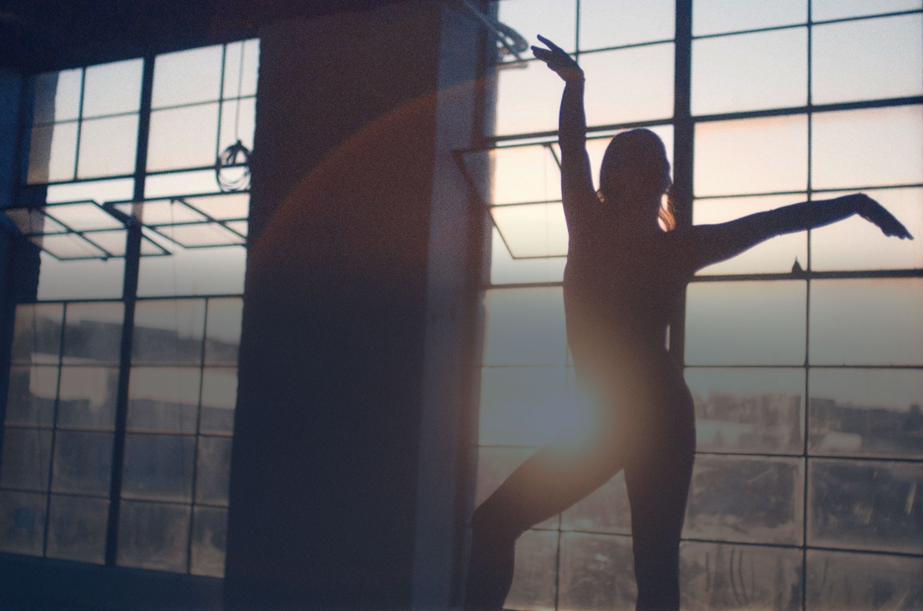 Aly practicing floor gymnastics silhouetted against a sunny window