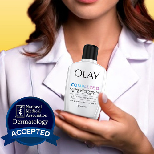 Model holding Olay Complete + Daily Facial Moisturizer with Sunscreen SPF 40 bottle. National medical association dermatology accepted.