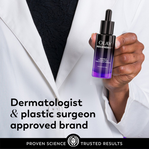 Model posing in lab coat holding Regenerist Wrinkle Correcting Night Treatment bottle. Dermatologist and plastic surgeon approved brand.