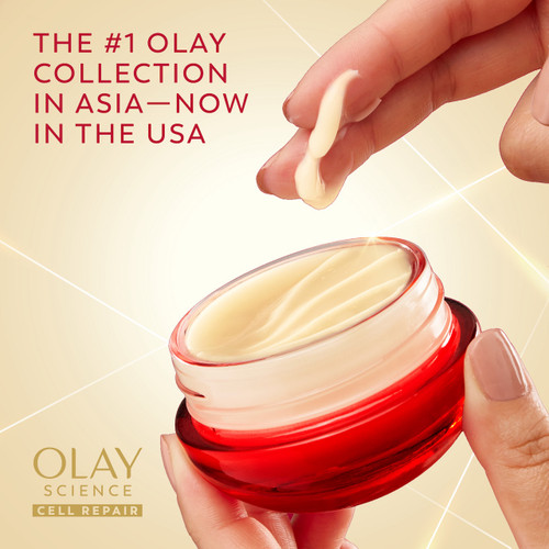Model holding OLAY Magic AA Soft Cream jar while dipping fingers in cream. The #1 Olay collection in Asia, now in the USA. Olay science cell repair