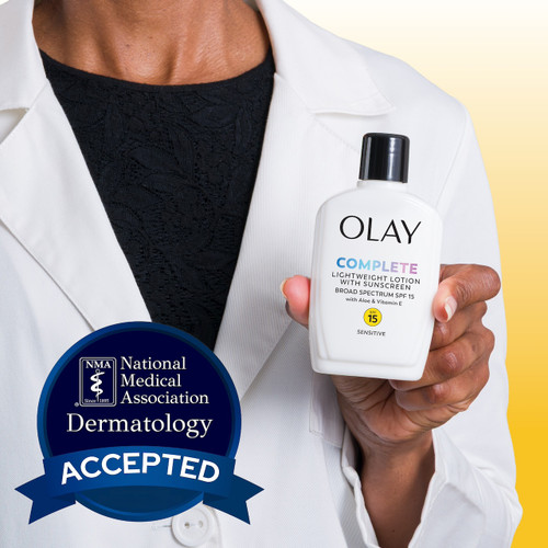 Model wearing lab coat holding Olay Complete Lotion Moisturizer with SPF 15 Sensitive bottle. National medical association dermatology accepted.