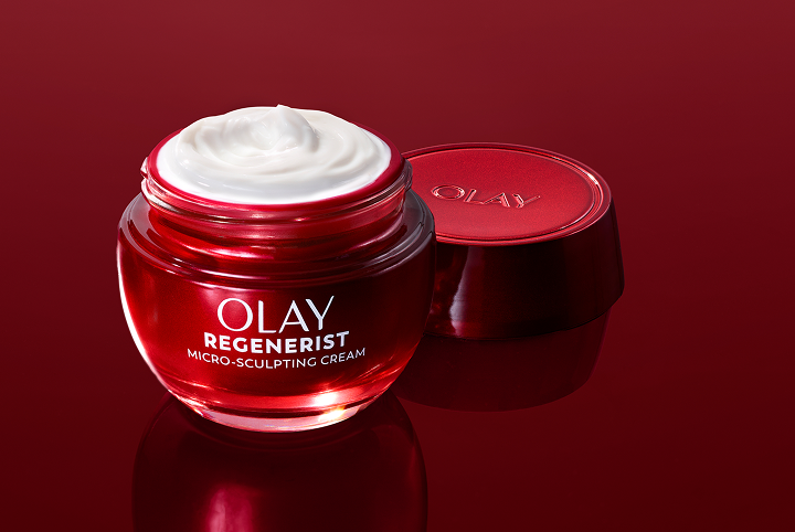 Brilliant red glass jar of Olay Micro-Sculpting Cream moisturizer with its lid removed and cream exposed alongside a People magazine Hall of Fame Winner award badge.