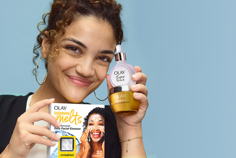 Laurie Hernandez smiling and holding up all three items in her gift set