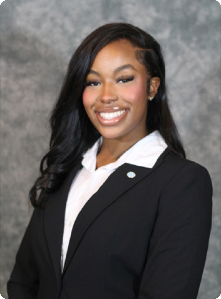 Close up image of Jordan Williams smiling and wearing a black suite