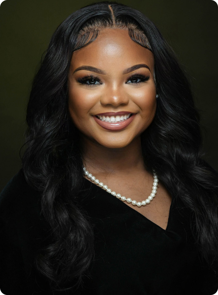 Close up image of Madison Johnson  smiling and wearing a pearl necklace