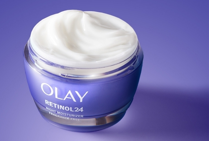 Olay Retinol 24 Night Face Moisturizer Cream in purple jar with rich white texture, emphasizing its anti-aging ingredients that smoothen the skin's surface overnight.