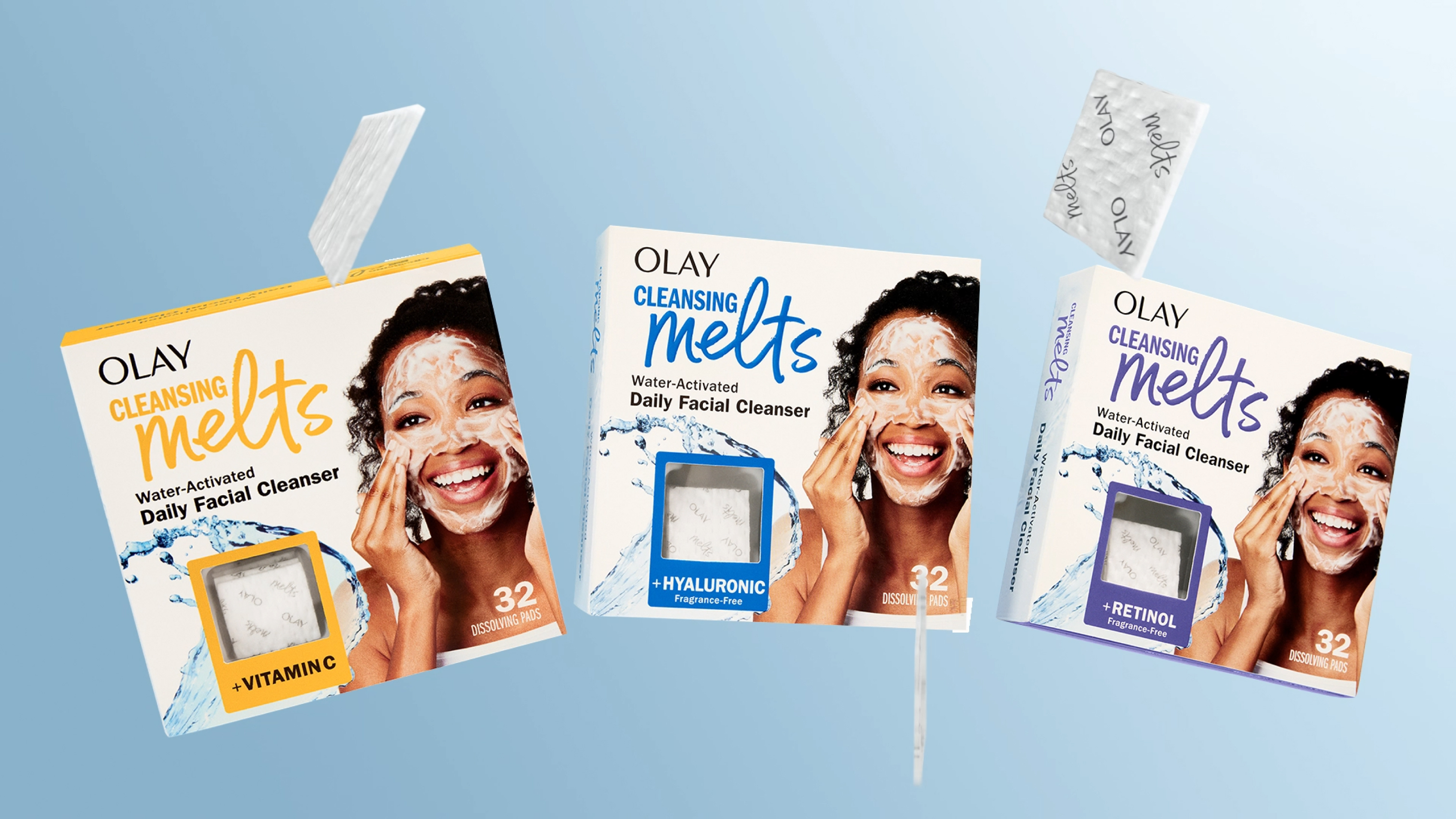 Three Olay Cleansing Melts packages floating with the individual melts square spinning beside them