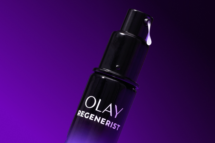 Zoomed in image of the top of the Olay Resurfacing Peel Night Treatment with its liquid coming out of the spout to show the texture of the product.