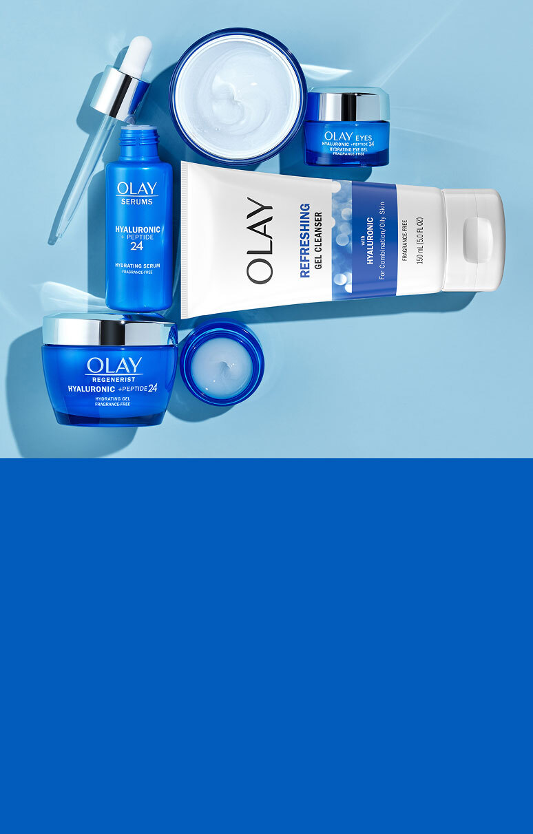 Olay Hyaluronic + Peptide 24 skincare line including cleanser, serum, gel cream, and eye gel arranged flat on a blue background.