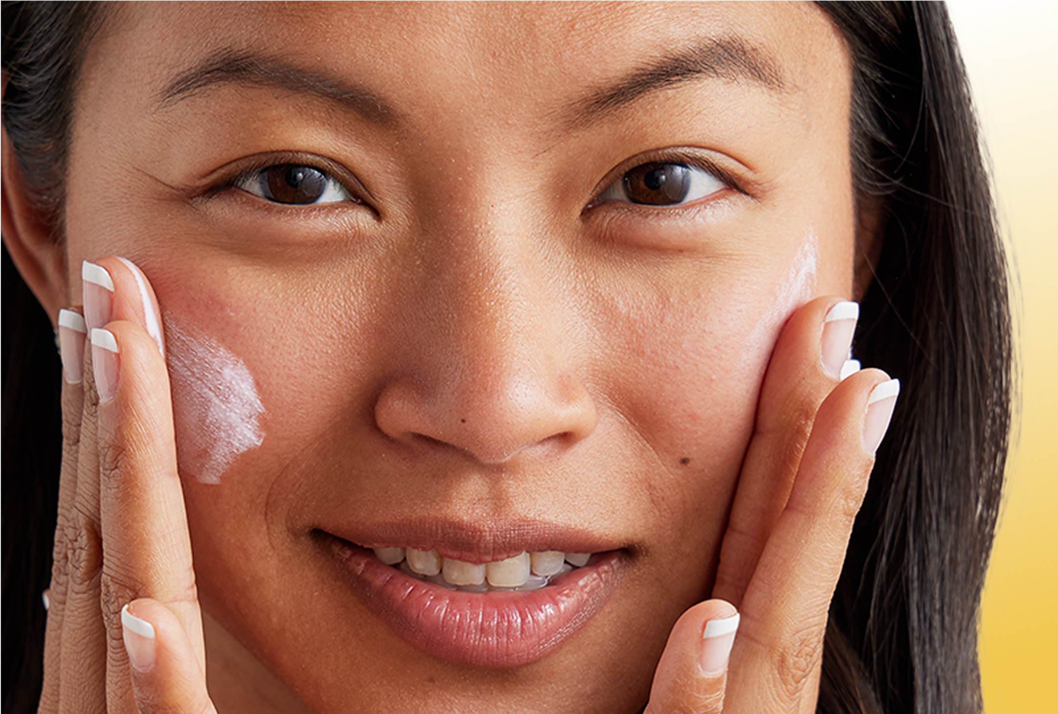 Woman clasping her face with both of her hands after applying Olay Complete Sensitive SPF 30 with a slight visible white cast to show it was just applied Woman clasping her face with both of her hands after applying Olay Complete Sensitive SPF 30 with a slight visible white cast to show it was just applied